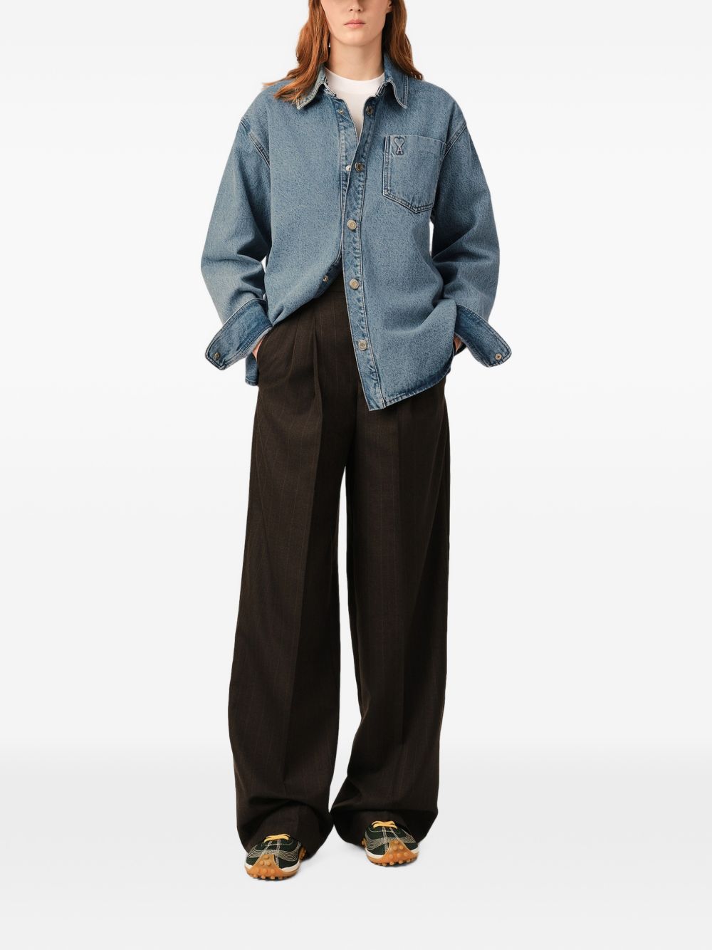 Het overshirt gedragen bij een zwarte wijde broek