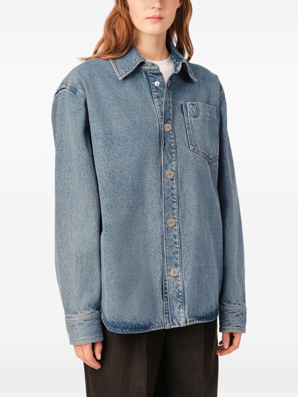 Zijaanzicht van het overshirt met afhangende schouder en gebogen zoom
