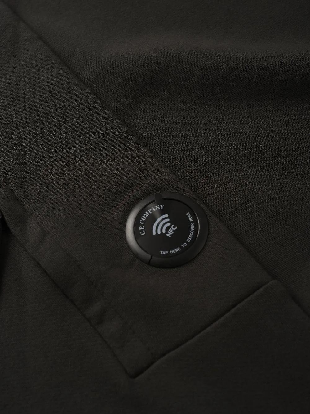 Detail van de mouwzak met iconisch C.P. Company-lensdetail