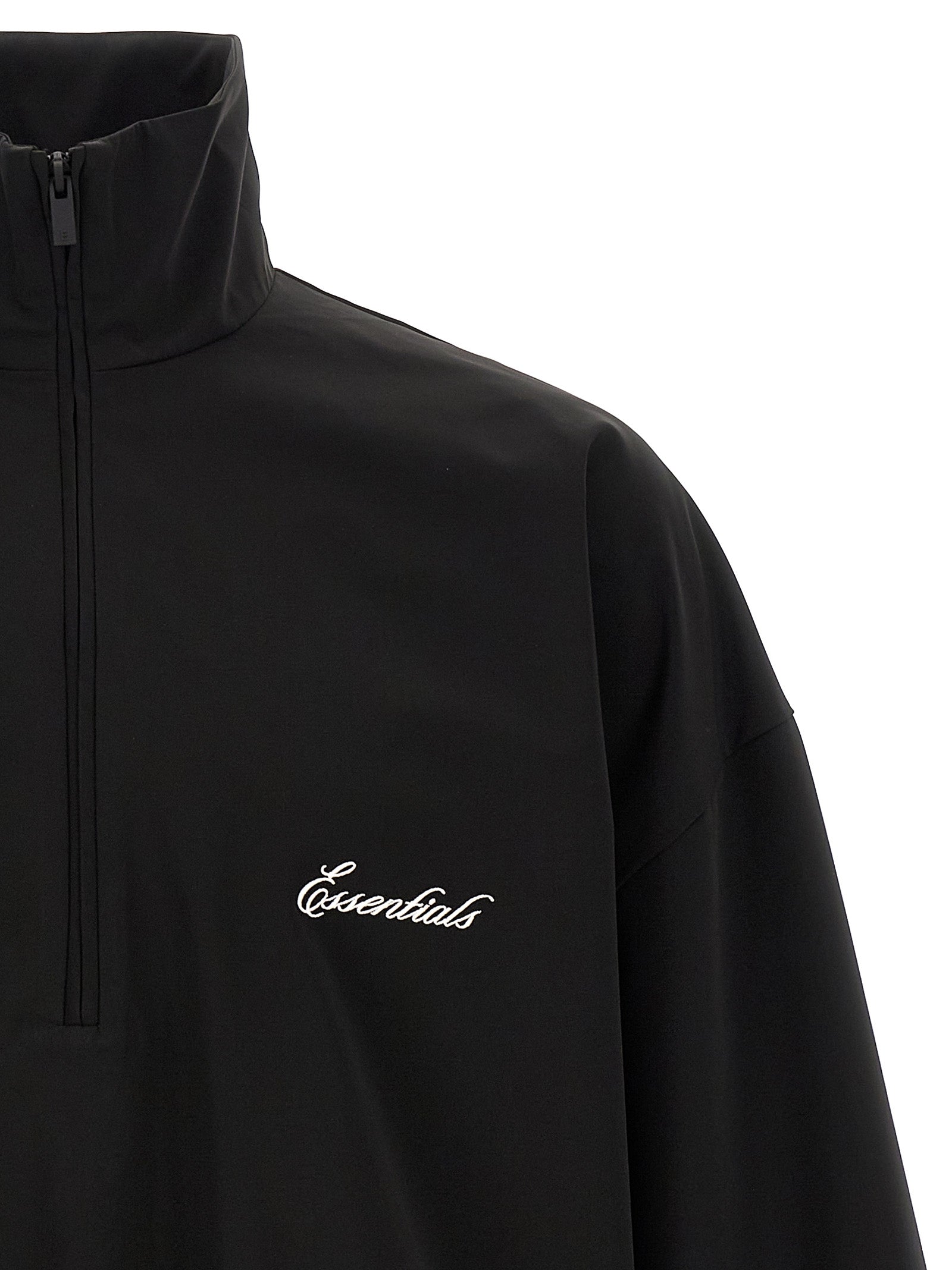 Detail van de halve rits en het cursief geborduurde Essentials-logo op de borst