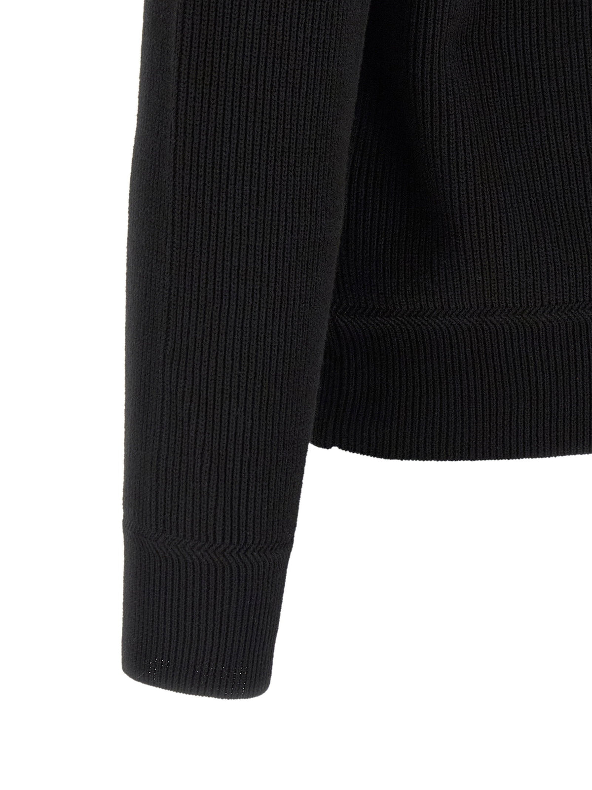 Detail van de geribde mouw en zoom van de Stone Island trui