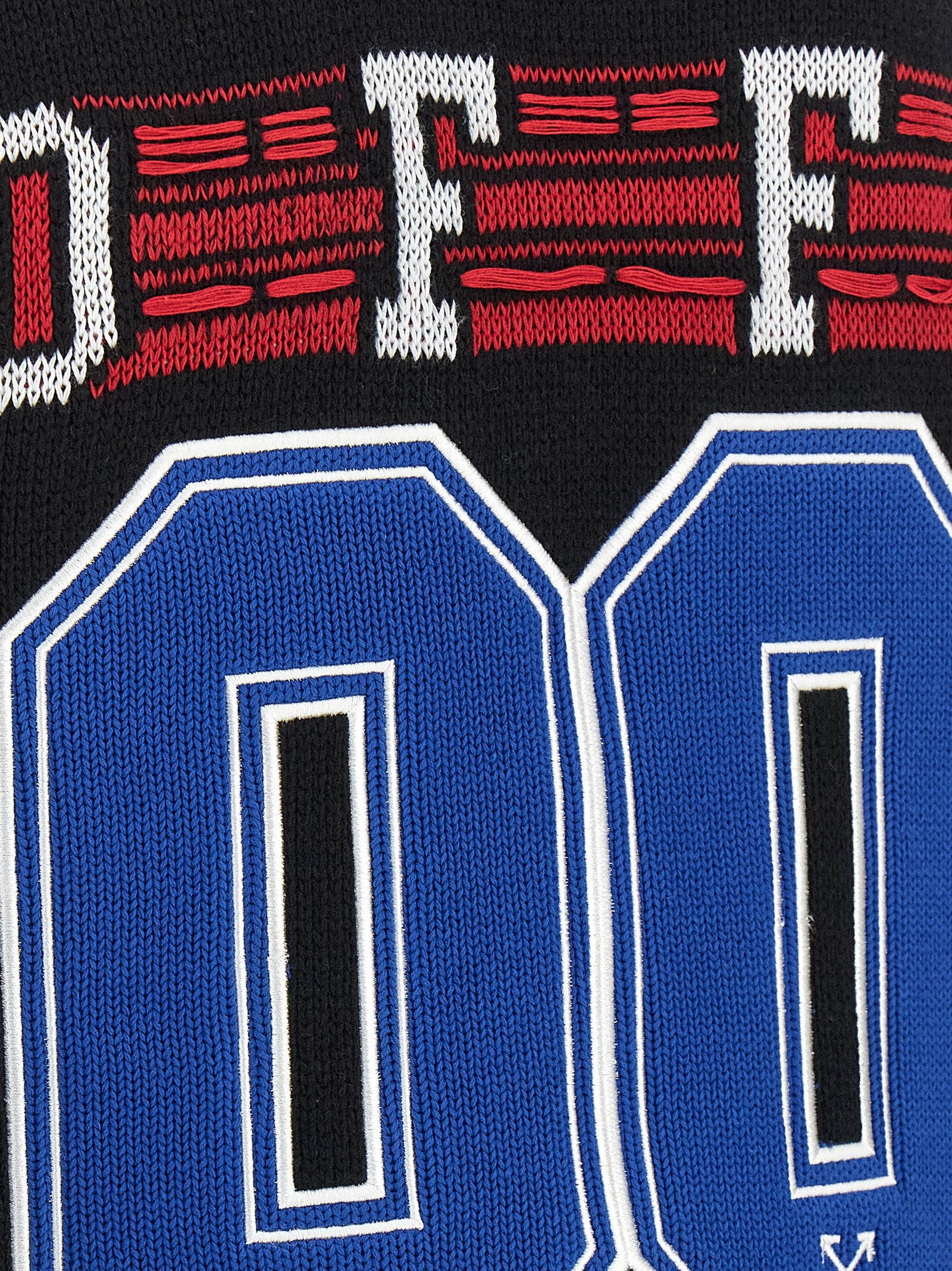 Close-up van de ingebreide letters in wit, rood en blauw