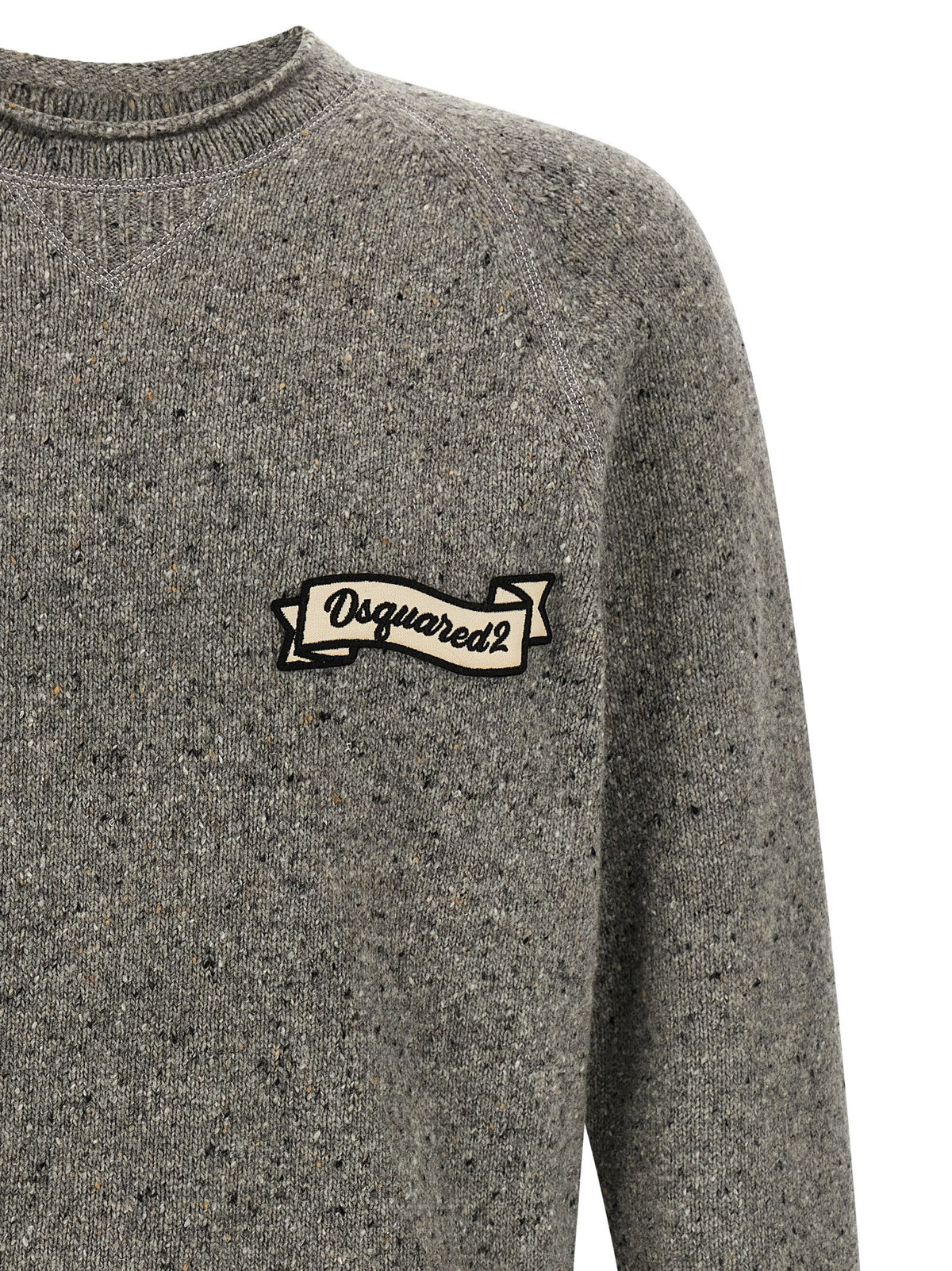 Detail van het crèmekleurige banierlabel en het gespikkelde breisel