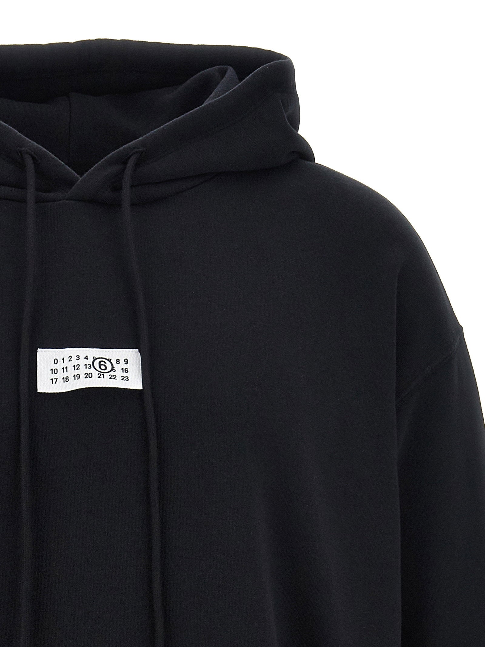 Witte stiklijn op de rug van de zwarte MM6 Maison Margiela hoodie