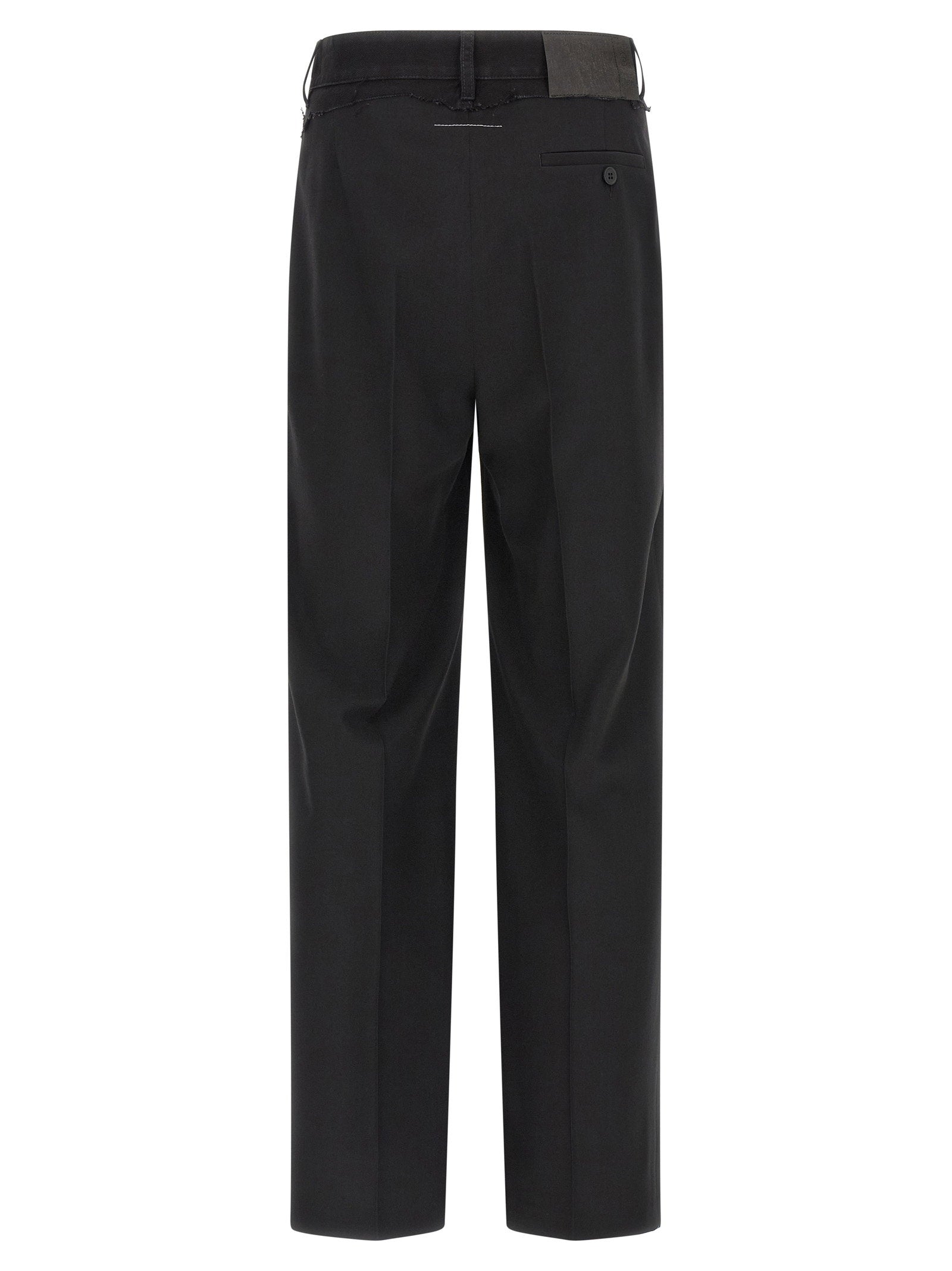 Achterkant van de MM6 pantalon met paspelzak en leerachtig jeanslabel op de tailleband