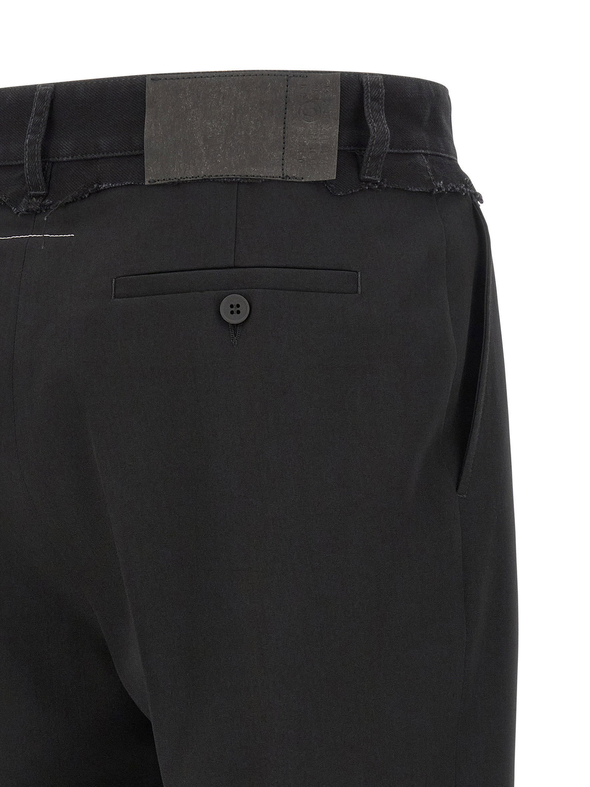 Detail van het ingeperste leerachtige jeanslabel achterop de denim tailleband