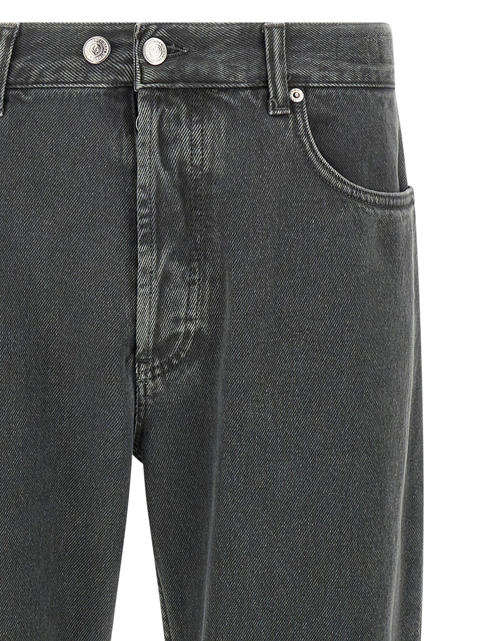 Detail van de knoopsluiting en de tailleband met riemlussen