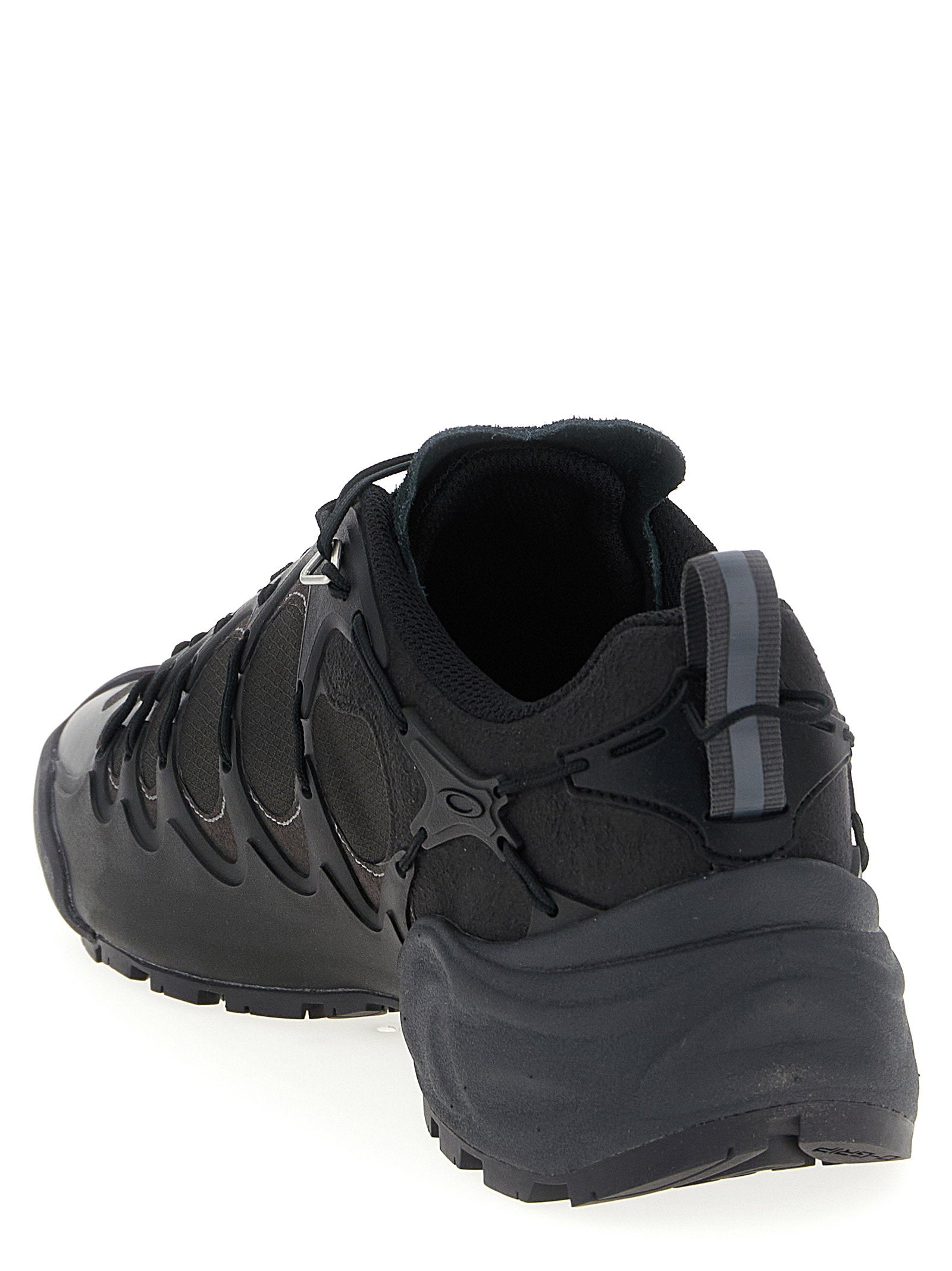 Zwarte technische sneaker met treklus en profielzool achteraanzicht